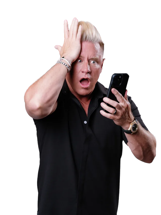 J Bravo with a hand on his head, staring at his phone