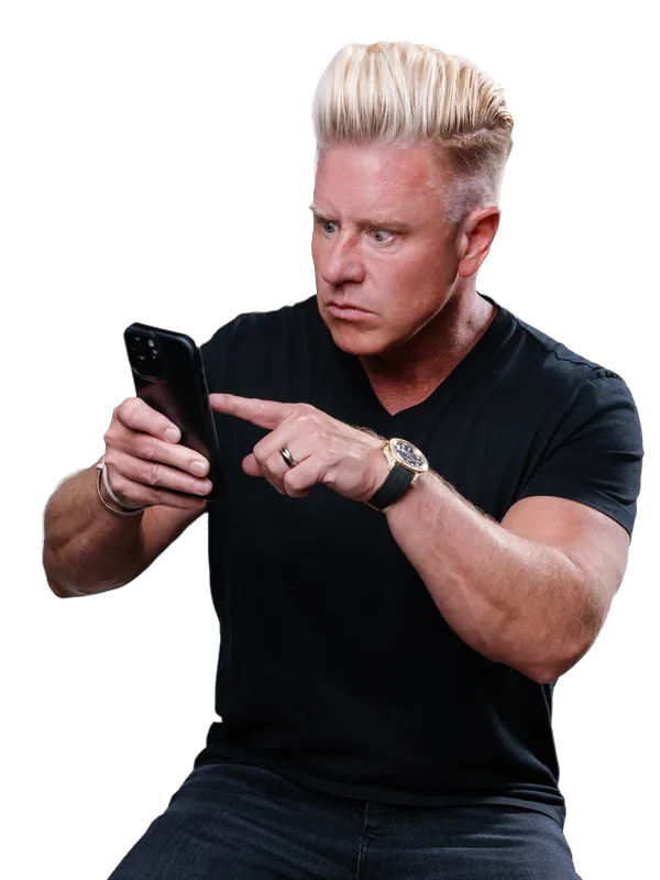 J Bravo pointing at his phone